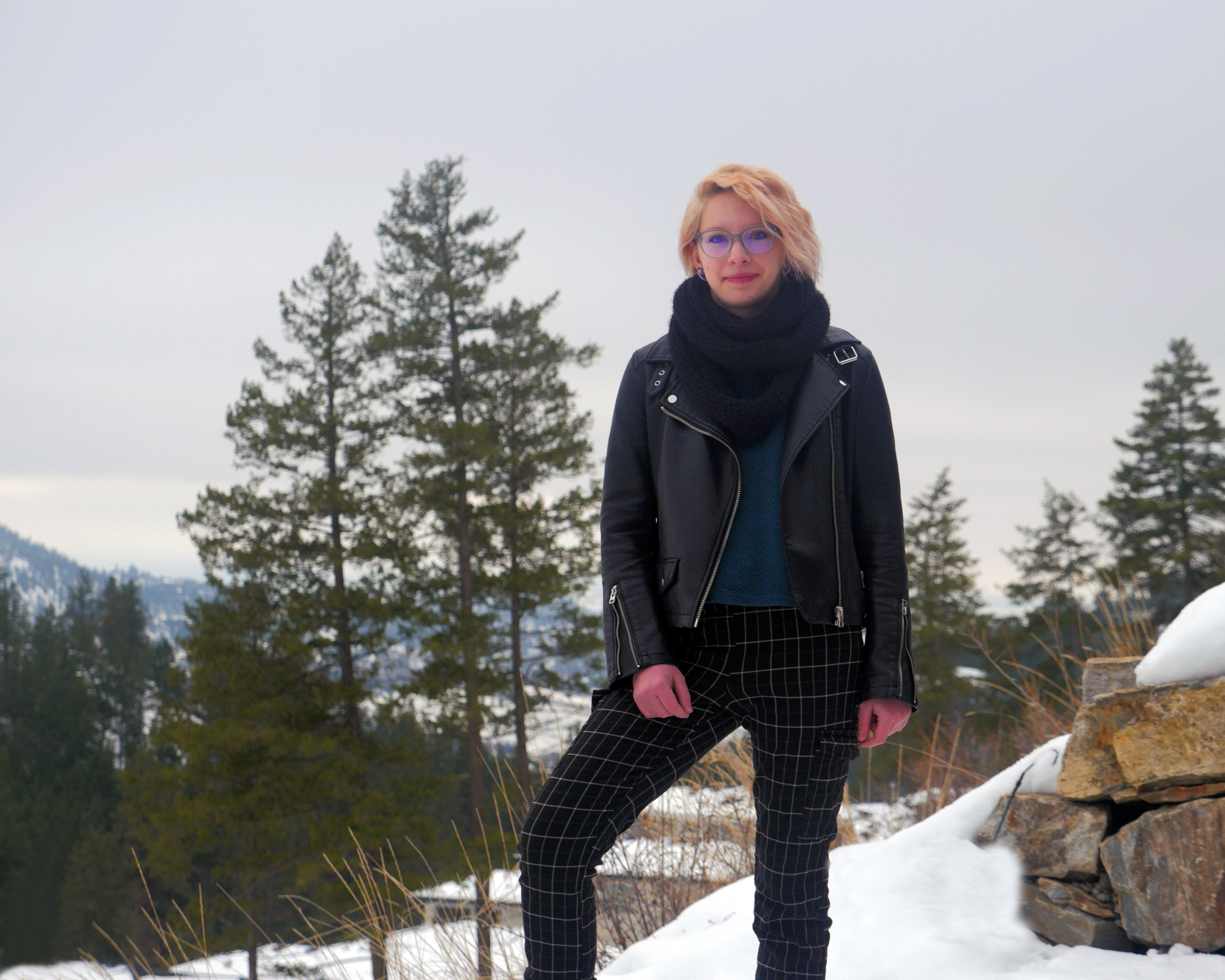 The author, Enya Duffield, outside smiling at the camera with trees and mountains in the background.